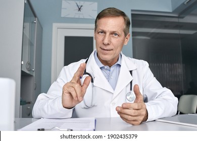 Middle aged old male doctor talking to webcam. Senior physician consulting patient online making video call telemedicine virtual tele meeting. E appointment, telehealth therapy concept. Web cam view