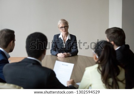 Middle aged senior confident woman applicant seeker talking to young hr managers at job interview making first impression, mature old female candidate speaking answering question, recruiting concept