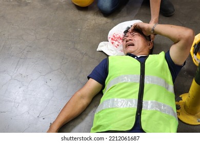 Middle Aged Warehouse Asian Worker Man Had Elbow Accident Lying On The Floor In Warehouse Logistics Distribution Center. Safety Colleague Team Helping Him From Injury. First Aid Training Concept.