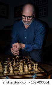 Middle Aged White Caucasian Man Thinking Critically And Planning His Next Move With Brow Furrowed During A Game Of Chess Which He Is Losing