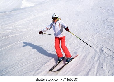 Middle Aged Woman Alpine Skiing In The Snow In Winter.