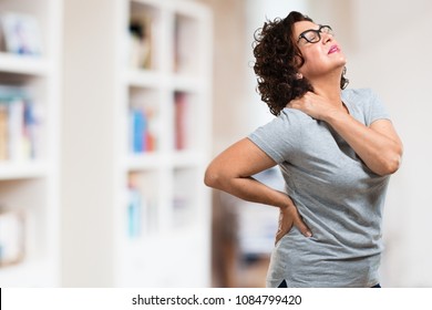 Middle Aged Woman With Back Pain Due To Work Stress, Tired And Astute