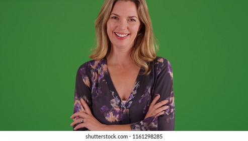 Middle aged woman in blouse smiling at camera on green screen - Powered by Shutterstock