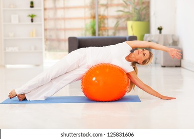 Middle Aged Woman Doing Fitness On Exercise Ball At Home