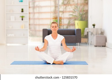 Middle Aged Woman Doing Yoga Meditation At Home