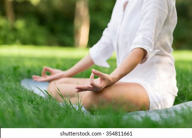 Middle Aged Woman Doing Yoga Early In The Morning In A Park