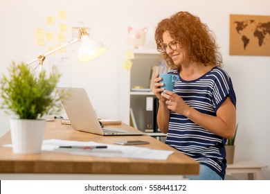 Middle Aged Woman Drinking A Hot Coffee At The Office