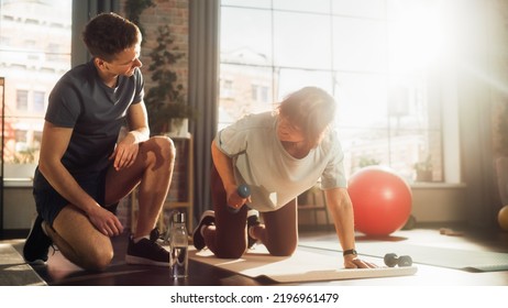 Middle Aged Woman Exercising at Home with Personal Trainer. Elderly Female Strengthening Core and Arm Muscles with Dumbbell Workout. Young Man Supporting and Guiding Her Through the Training. - Powered by Shutterstock