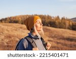 Middle aged woman hiking and going camping in nature. Person with backpack walking in autumn forest
