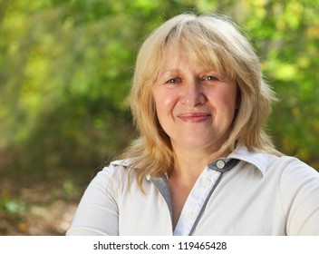 Middle Aged Woman Looking At Camera With Happy Smile