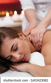 a middle aged woman lying on a massage table in a beauty salon with hot stones on her back