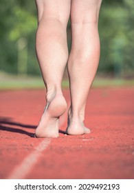 Middle Aged Woman And Mother  Running On Stadium Track During Sunny Morning 