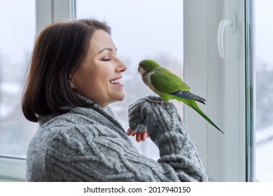 Middle Aged Woman And Parrot Together, Female Bird Owner Talking Looking At Green Quaker Pet