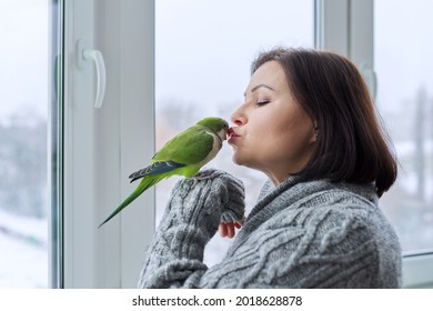 Middle Aged Woman And Parrot Together, Female Bird Owner Talking Kissing Green Quaker Pet