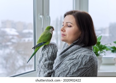 Middle Aged Woman And Parrot Together, Female Bird Owner Talking Looking At Green Quaker Pet