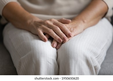 Middle aged woman placing hands on lap, making stack of palms in waiting anxious position. Close up of beautiful female arms of mature 50s lady with fine wrist skin, manicure, polished fingernails - Shutterstock ID 1950650620