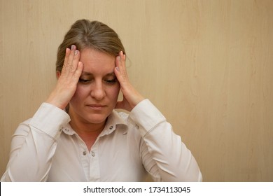 Middle Aged Woman Portrait Touching Her Head Temples With Hands. 40 Years Woman Not Looking At Camera. White Business Shirt Is Dressed. Sad Face And Negative Emotions