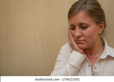 Middle Aged Woman Portrait Touching Her Face With Hand. 40 Years Woman Not Looking At Camera. White Business Shirt Is Dressed. Sad Face And Negative Emotions