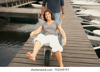 Middle Aged Woman Pushed In Wheel Barrow