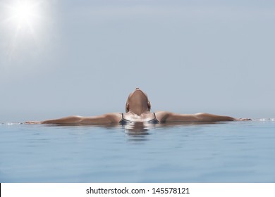 Middle Aged Woman Relaxing In Infinity Pool