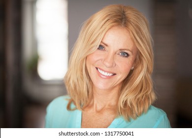 Middle aged woman smiling at the camera at home