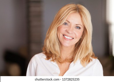 Middle Aged Woman Smiling At The Camera At Home. White	