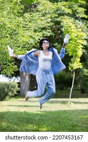 Middle Aged Woman  In A Suit Without Sneakers Walks Barefoot On The Grass In The Park. Enjoying The Little Things. Lykke Concept. Relaxation Concepts
