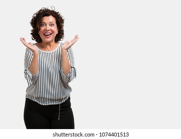 Middle aged woman surprised and shocked, looking with wide eyes, excited by an offer or by a new job, win concept