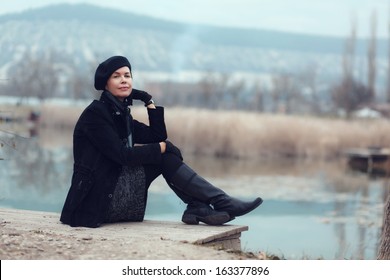 Middle Aged Woman Walking In Autumn Park Looking Away