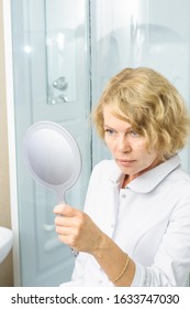 middle aged woman in white medicine coat looking into mirror. Doctor female, medical professional - Shutterstock ID 1633747030