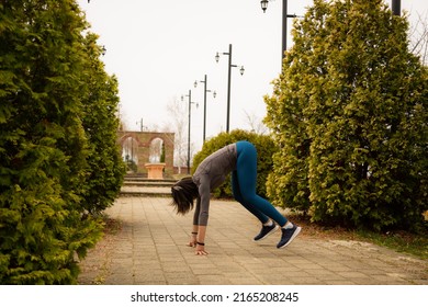 Middle Aged Woman Working Out Between The Bushes In The Park