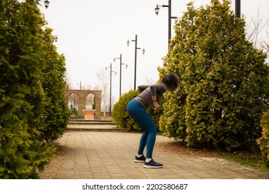 Middle Aged Woman Working Out Between The Bushes