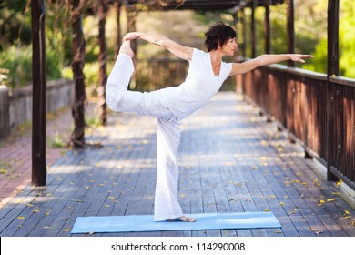 middle aged woman yoga pose outdoors - Powered by Shutterstock