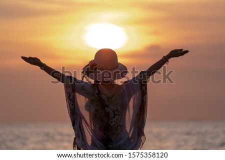 Middle Aged Women Hapy Lift their Arms out while on Sunset  at Beach.