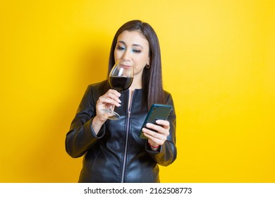 Middle Aged Young Woman Drinking Wine And Using Cell Phone