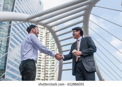Middle Asian business men shaking hands finished agreement after meeting.