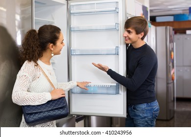 Middle Class Family Couple Choosing New Refrigerator In Hypermarket 