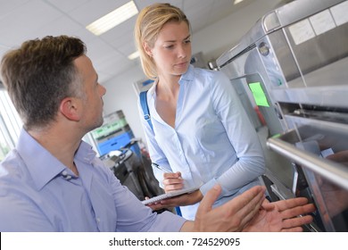 Middle Class Family Couple Choosing New Refrigerator In Hypermarket