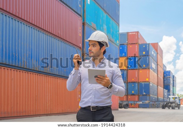 Middle east logistic worker engineer man working\
in cargo container warehouse industry factory site in export,\
import, and transportation concept. Business people lifestyle.\
Distribution service.