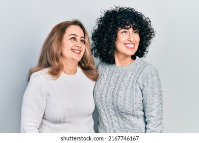 Middle East Mother And Daughter Wearing Casual Clothes Looking Away To Side With Smile On Face, Natural Expression. Laughing Confident. 