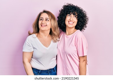 Middle East Mother And Daughter Wearing Casual Clothes Looking Away To Side With Smile On Face, Natural Expression. Laughing Confident. 