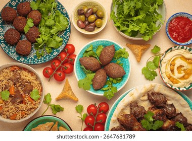 Middle eastern or Arab dishes and assorted meze on light beige background. Meat kebab, falafel, hummus, sambusak, rice, kibbeh, pita. Halal food. Lebanese cuisine