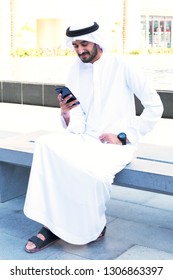 Middle Eastern Arab Man Chatting On Mobile Phone While Sitting Outdoors