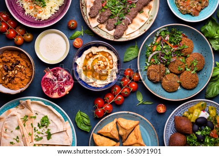 Middle eastern or arabic dishes and assorted meze, concrete rustic background. Meat kebab, falafel, baba ghanoush, muhammara, hummus, sambusak, rice, tahini, kibbeh, pita. Halal food. Lebanese cuisine