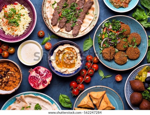 Middle eastern or arabic dishes and assorted
meze, concrete rustic background. Meat kebab, falafel, baba
ghanoush, muhammara, hummus, sambusak, rice, tahini, kibbeh, pita.
Halal food. Lebanese
cuisine