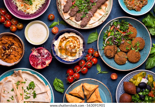 Middle eastern or arabic dishes and assorted
meze, concrete rustic background. Meat kebab, falafel, baba
ghanoush, muhammara, hummus, sambusak, rice, tahini, kibbeh, pita.
Halal food. Lebanese
cuisine