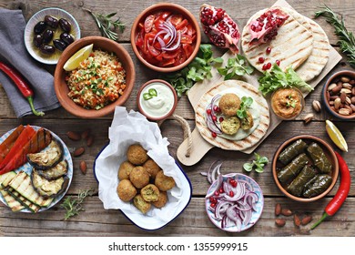 Middle Eastern, Arabic Or Mediterranean Appetizers Table Concept With Falafel, Pita Flatbread, Bulgur And Tomato Salads, Grilled Vegetables, Stuffed Grape Leaves,olives And Nuts.