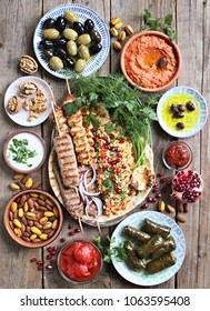 Middle Eastern, Arabic Or Mediterranean Dinner Table With Grilled Lamb Kebab, Chicken Skewers  With Roasted Vegetables And Appetizers Variety Serving On Party Outdoor Table. Overhead View.