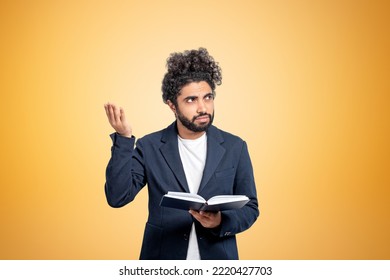 Middle Eastern Businessman With A Hand Up, Asking Questions. Confused Man Portrait With Notebook In Hand, Copy Space Yellow Background. Concept Of Difficult Task