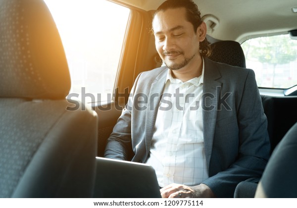 middle\
eastern businessman inside a car\
passenger\
